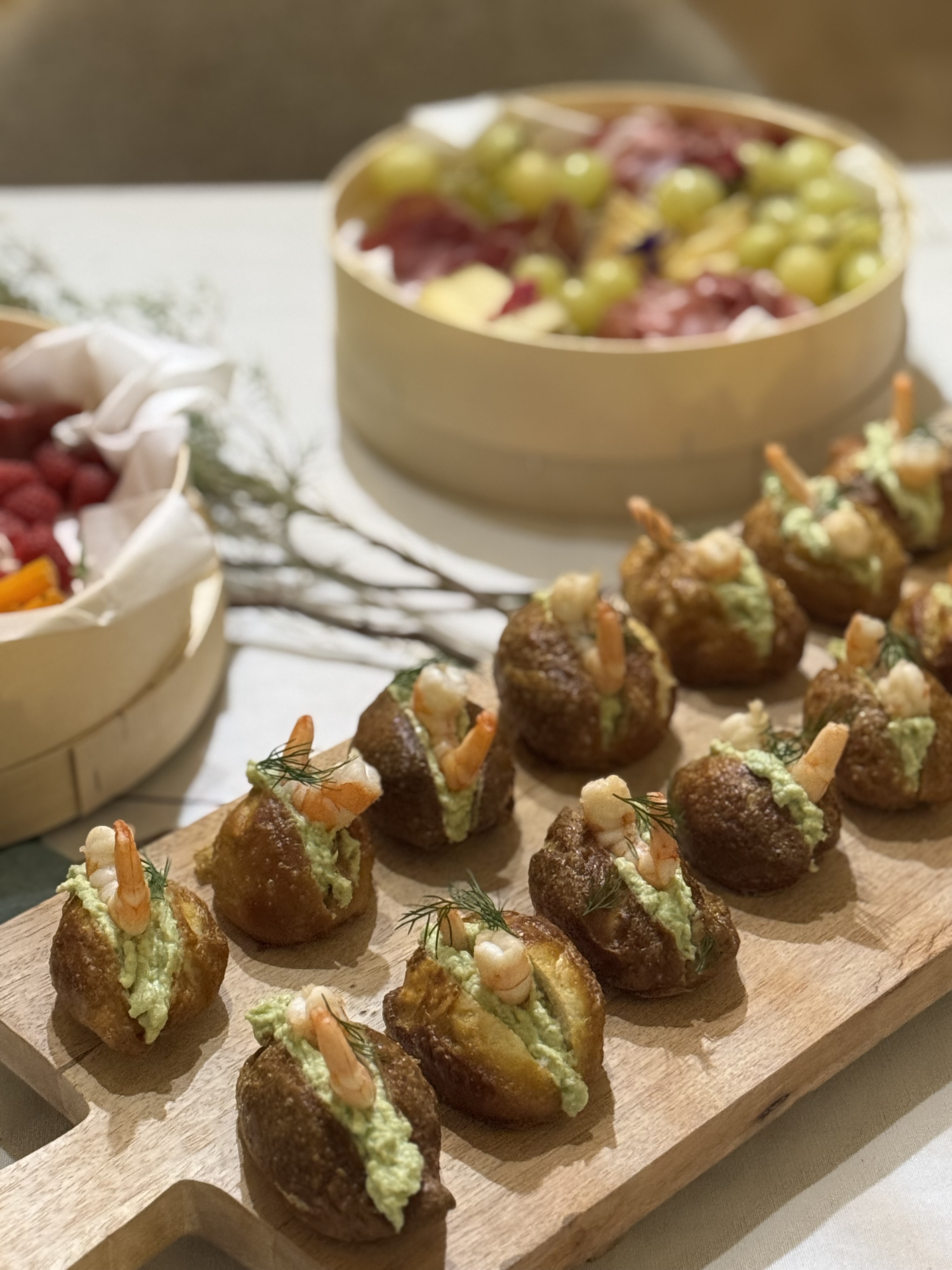 Petits choux farcis crevettes et avocat sur planche en bois